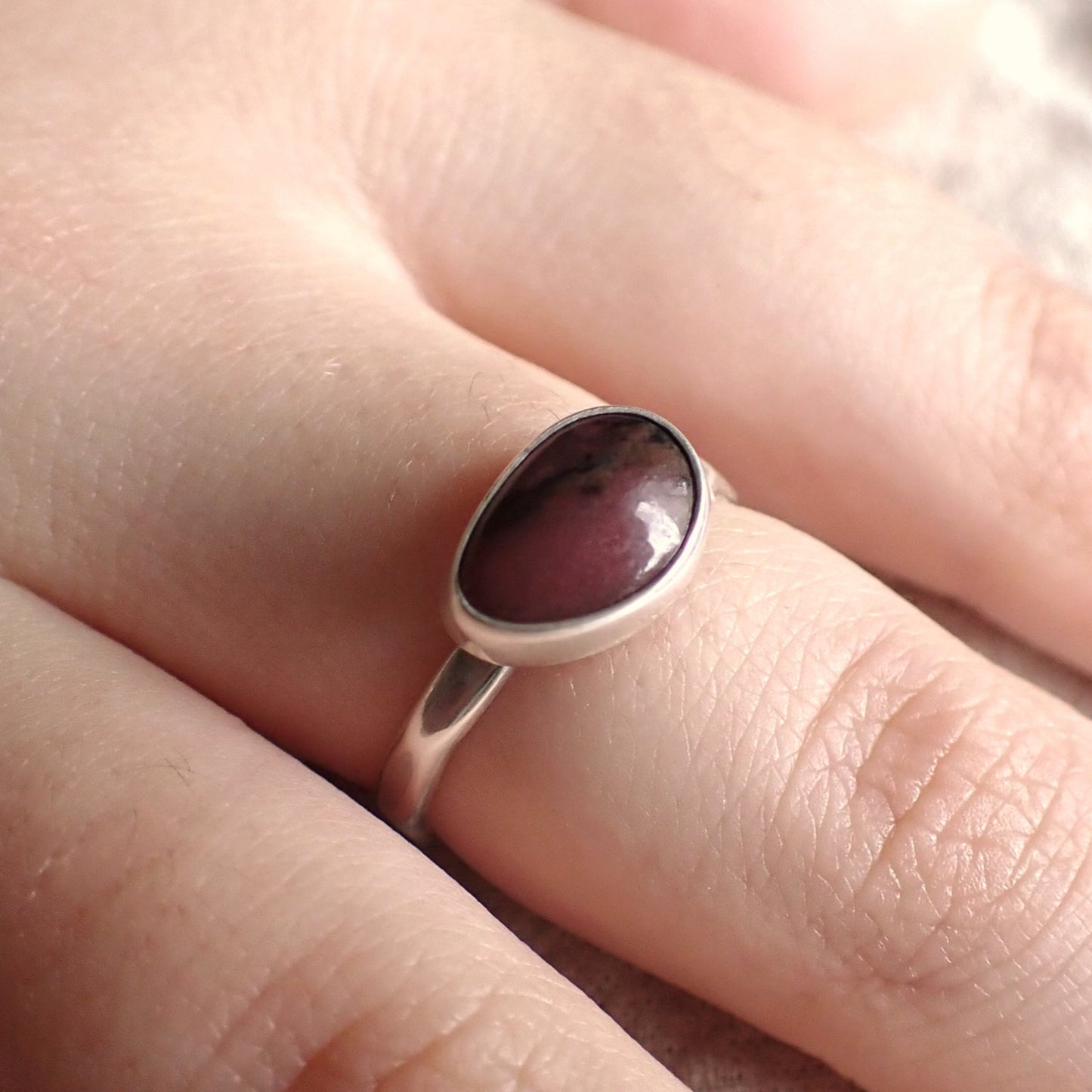 a worn photo of the black cherry ring to show that it is a very dark pink in low light