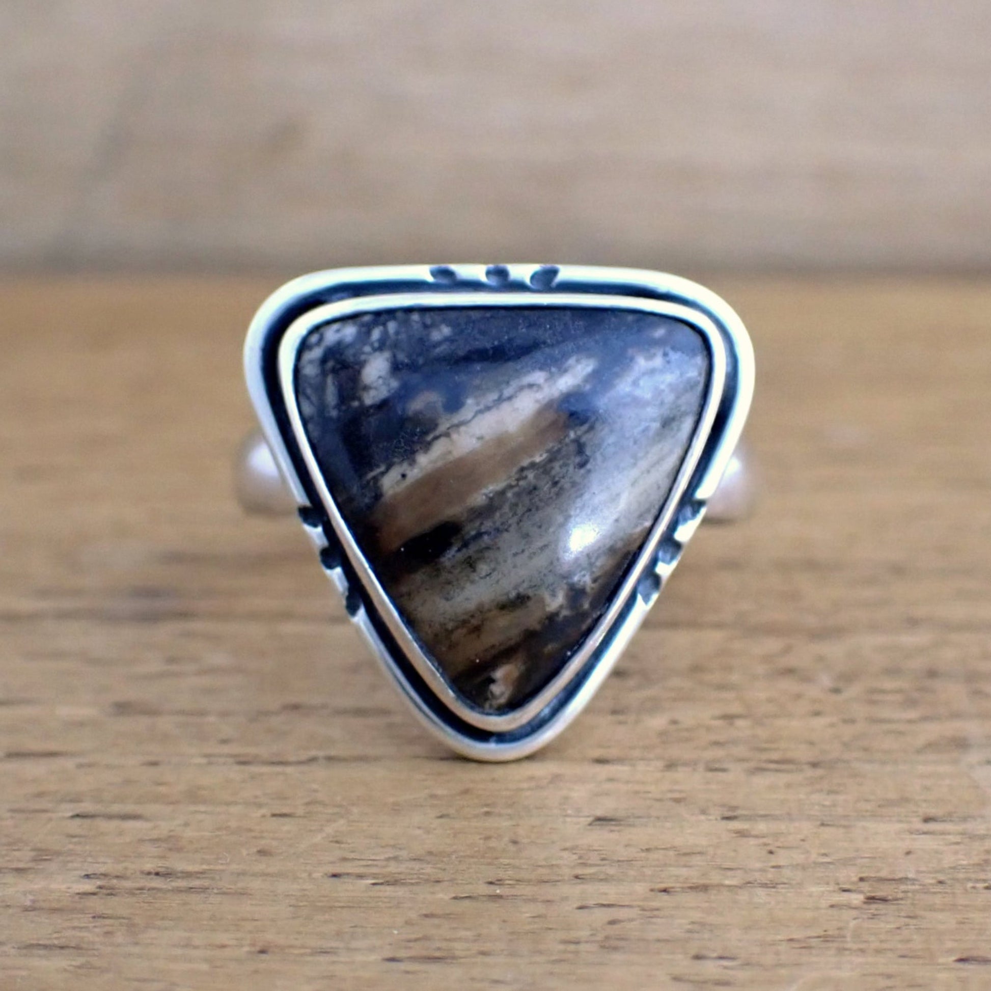 a face on view of the Amaya ring on a raw wood surface 
