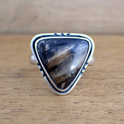 a face on view of the Amaya ring on a raw wood surface 