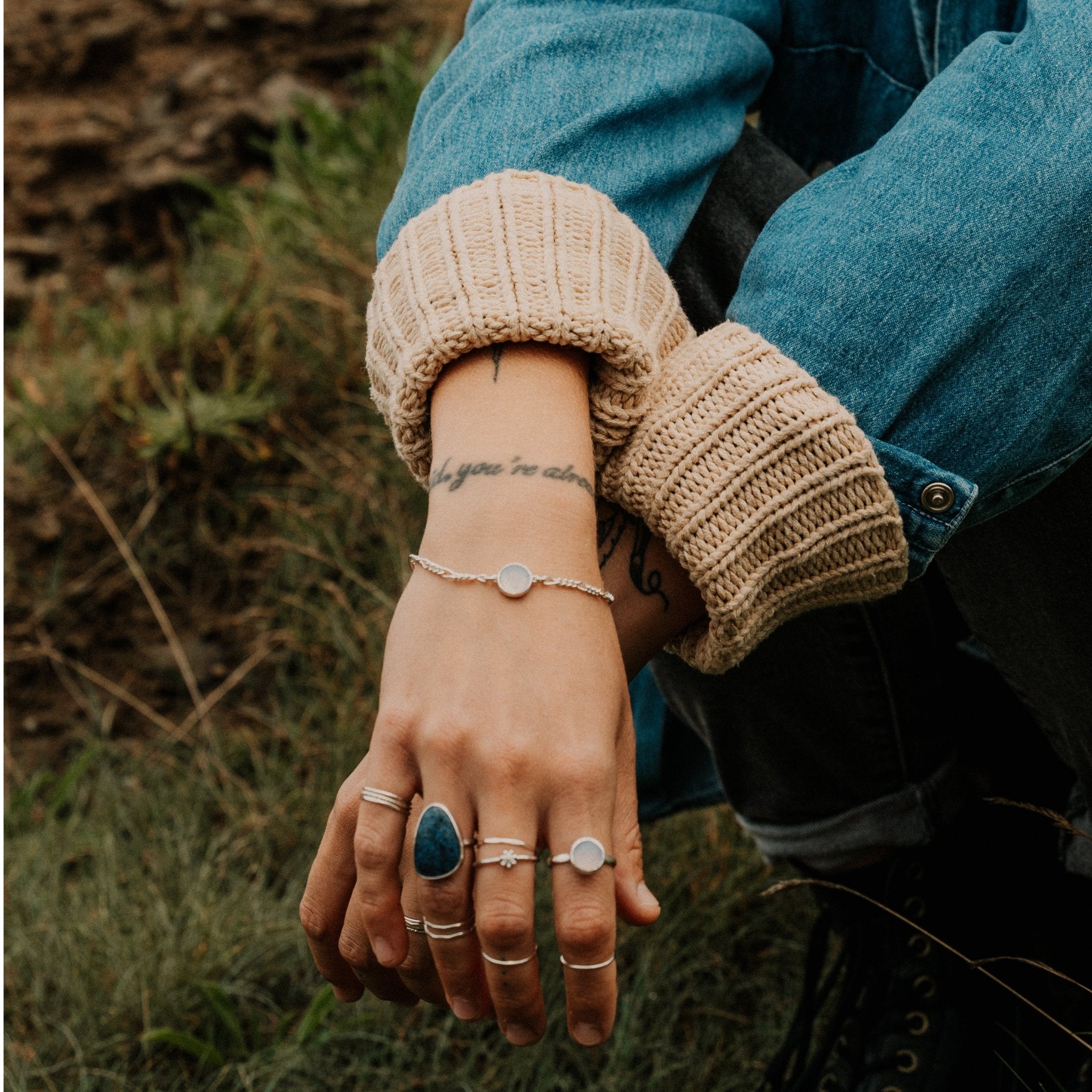 modelled photo of large statement blue stone ring and various other silver ring designs