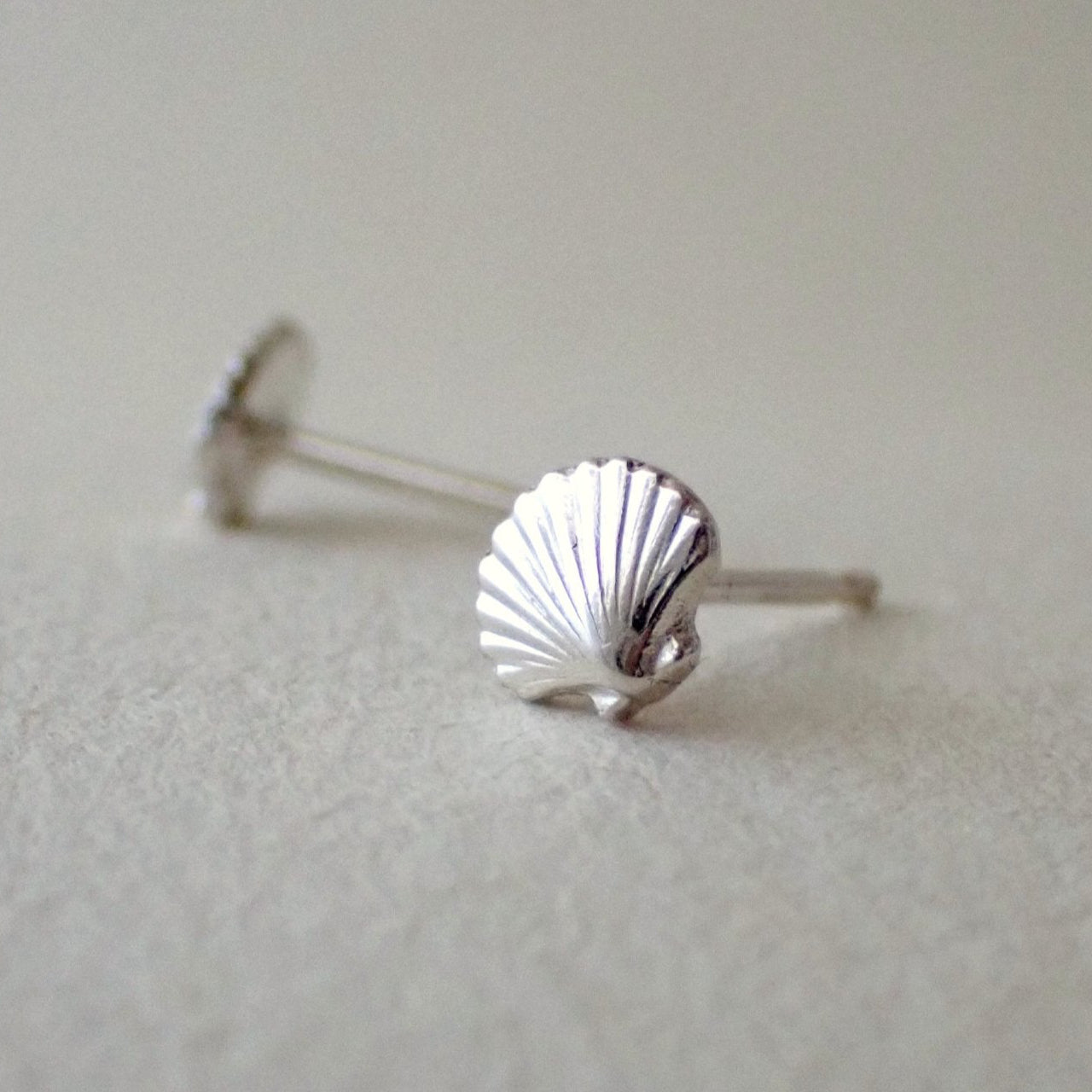 close up detail of a handmade scallop shell earring to show its 3D quality