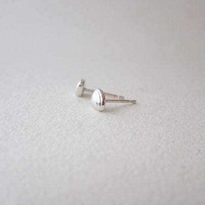 side view of handmade silver clamshell earrings to show depth of metal - 3D clamshell (domed with a flat back to sit against your earlobe) and with no sharp edges