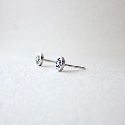 side view of hand-stamped sunshine earrings to show reasonably thick metal is used (this is slightly domed outwards to make the design more visible)