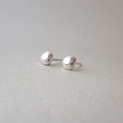 a pair of brighly polished and very shiny dinky clamshell stud earrings